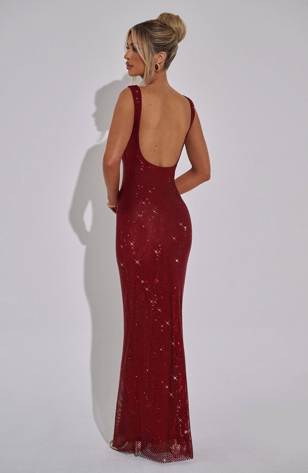 Back view of burgundy sparkly maxi dress with open back design