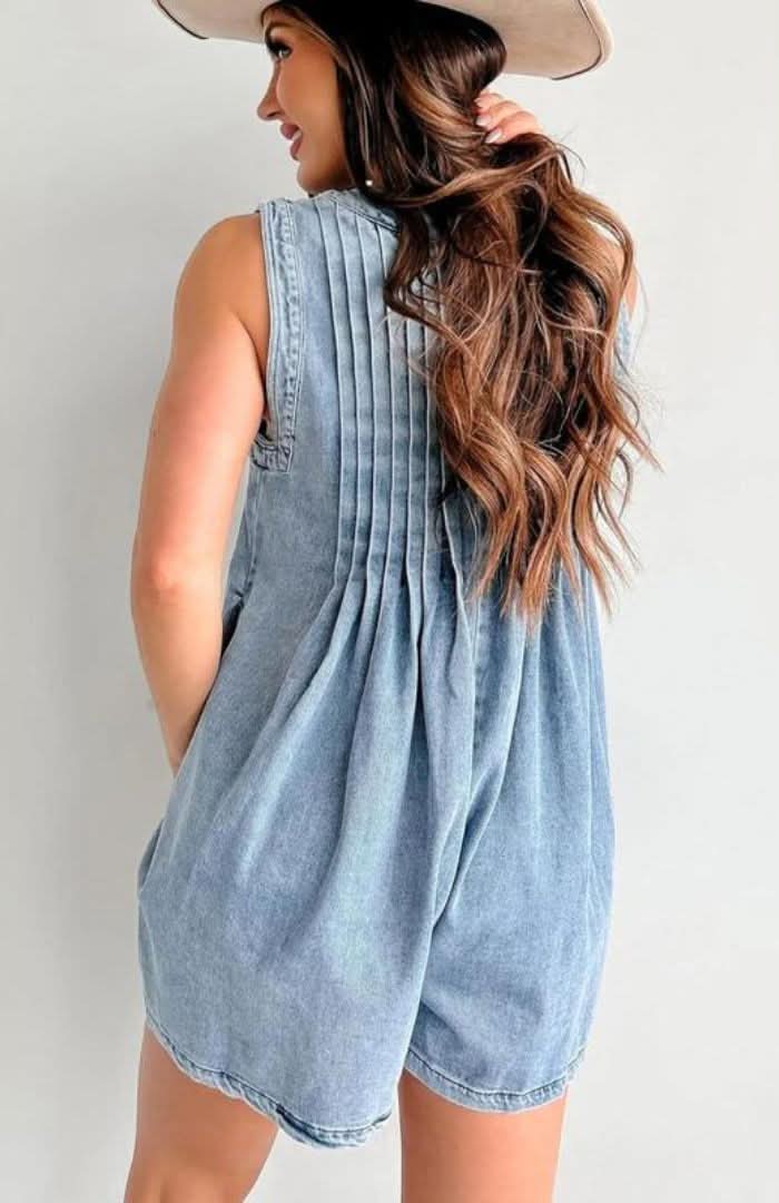 Back view of light blue denim romper showing pleated back and pockets