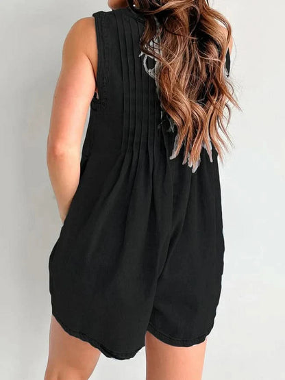 Black denim romper back view with pleated design and rounded hem