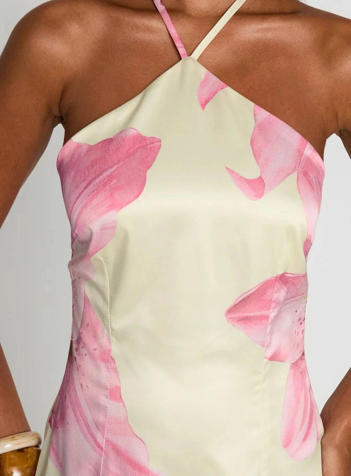 Chest detail showing pink floral pattern on cream halter mini dress fabric