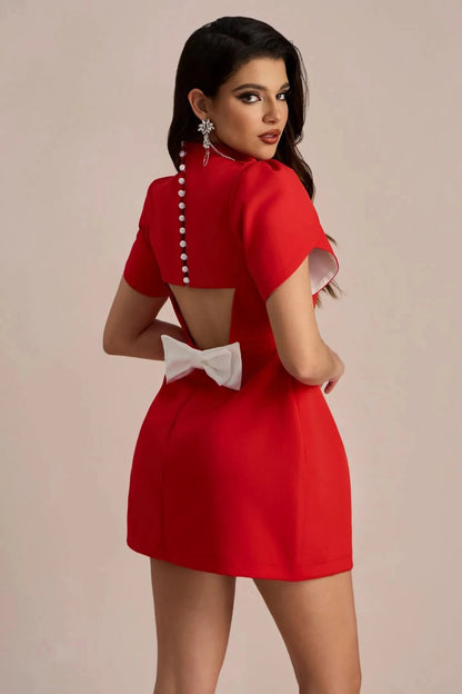 Back view of red mini dress with white bow and pearl button details