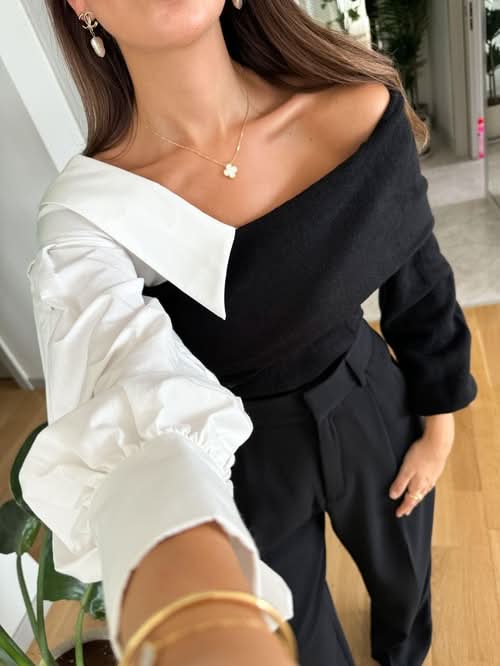 Close-up of black and white two-tone sweater neckline with draped white collar