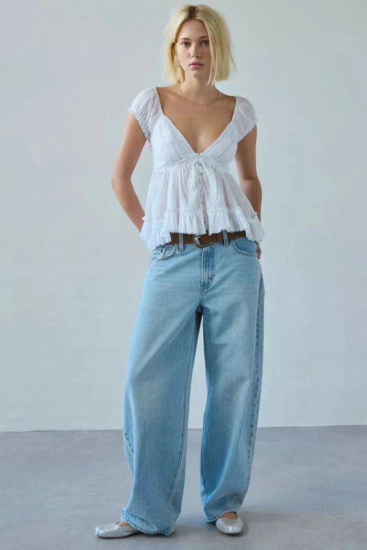 White peplum blouse with V-neckline and puff sleeves styled with light blue jeans for women