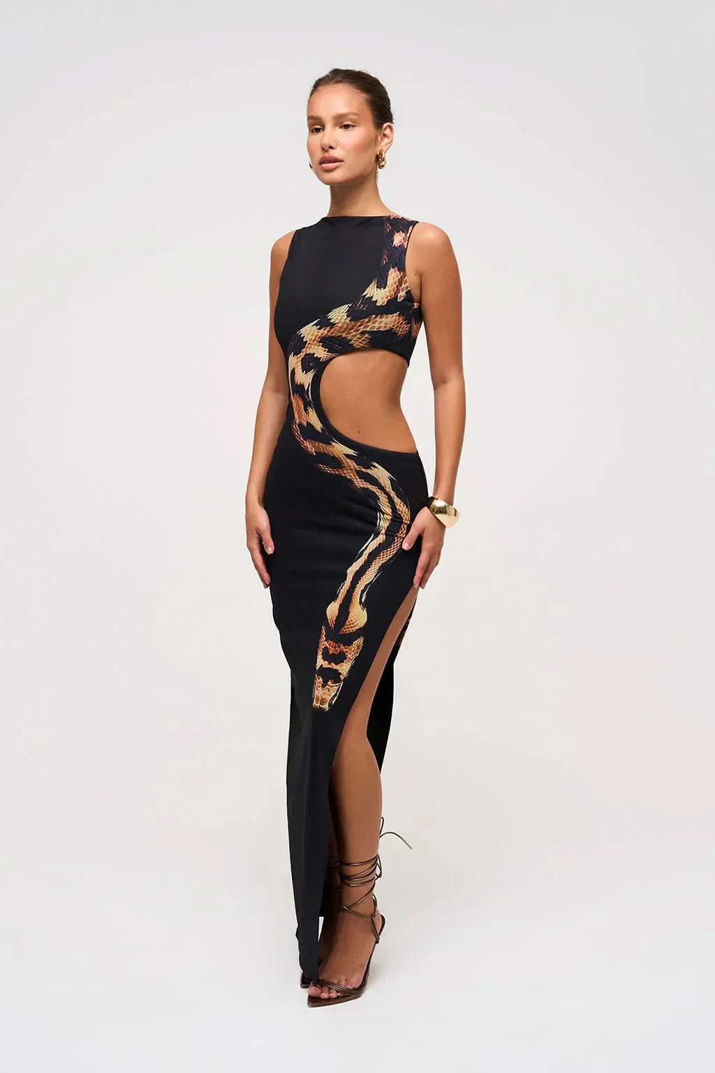 Side view of black sleeveless maxi dress with snake print and side slit
