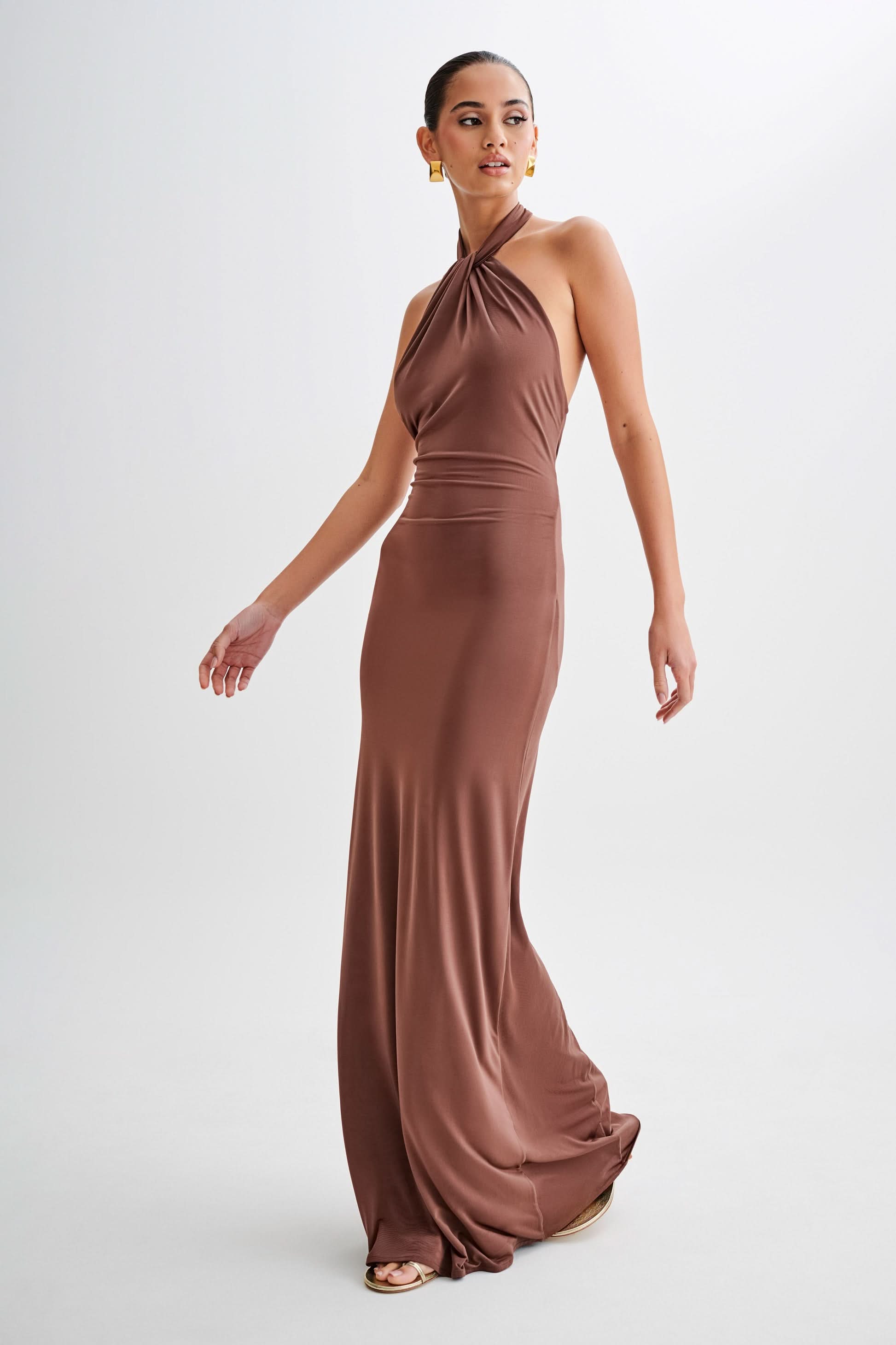 Side profile of taupe halter maxi dress with flowing train