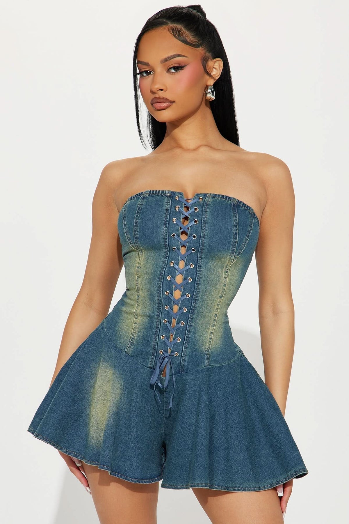 Medium wash denim romper with strapless corset lace-up front and flared mini skirt for women