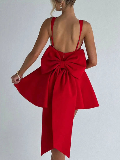 Back view of red mini dress featuring large bow detail and open back