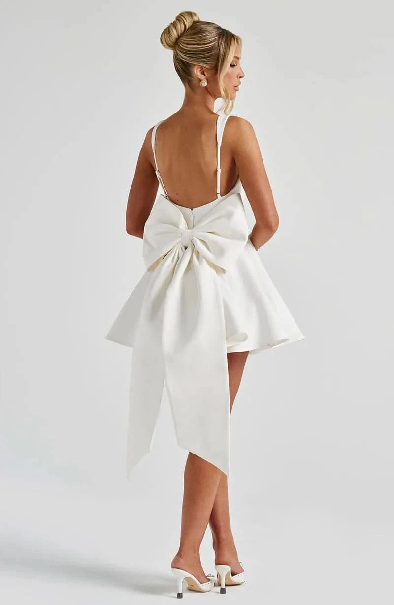 Back view of ivory mini dress with large bow detail at open back