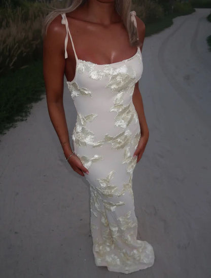 Close-up of cream maxi dress with yellow leaf embroidery, tie-shoulder straps and fitted bodice