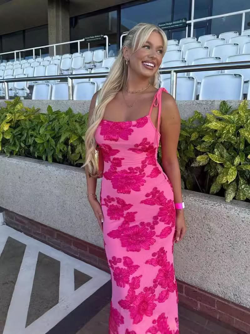 Pink sleeveless maxi dress with bold magenta floral pattern and fitted mermaid shape