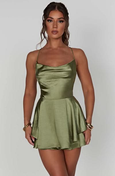 Sage green satin playsuit with draped neckline and tiered ruffle skirt
