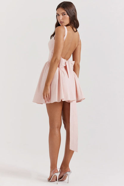 Blush pink sleeveless bow mini dress with flowing pleated skirt