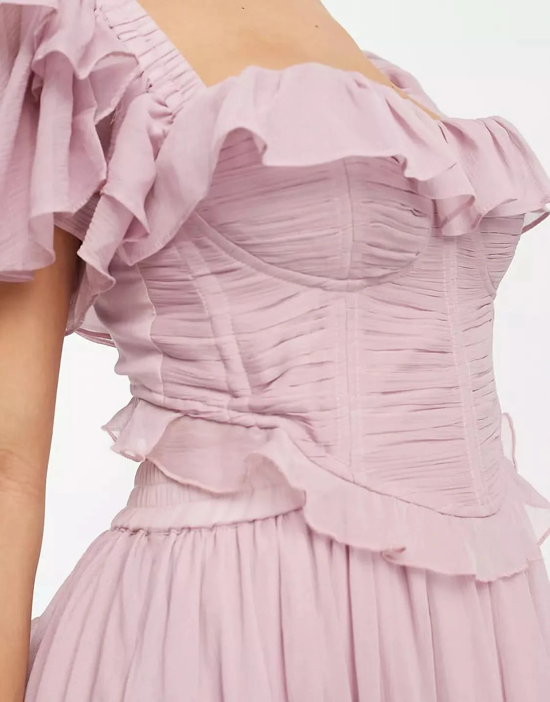 Close-up of ruched bodice and ruffled neckline on pink midi dress
