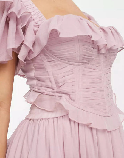 Close-up of ruched bodice and ruffled neckline on pink midi dress