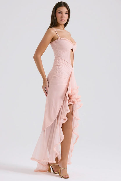 Side view of blush pink maxi dress with cutout detail and flowing ruffled train