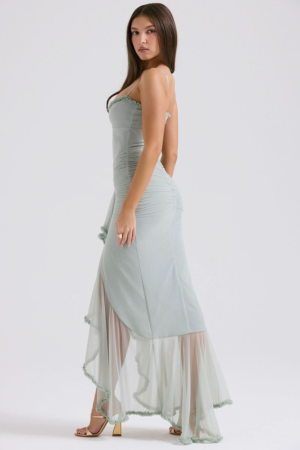 Side view of sage green maxi dress with cutout detail and layered ruffled train