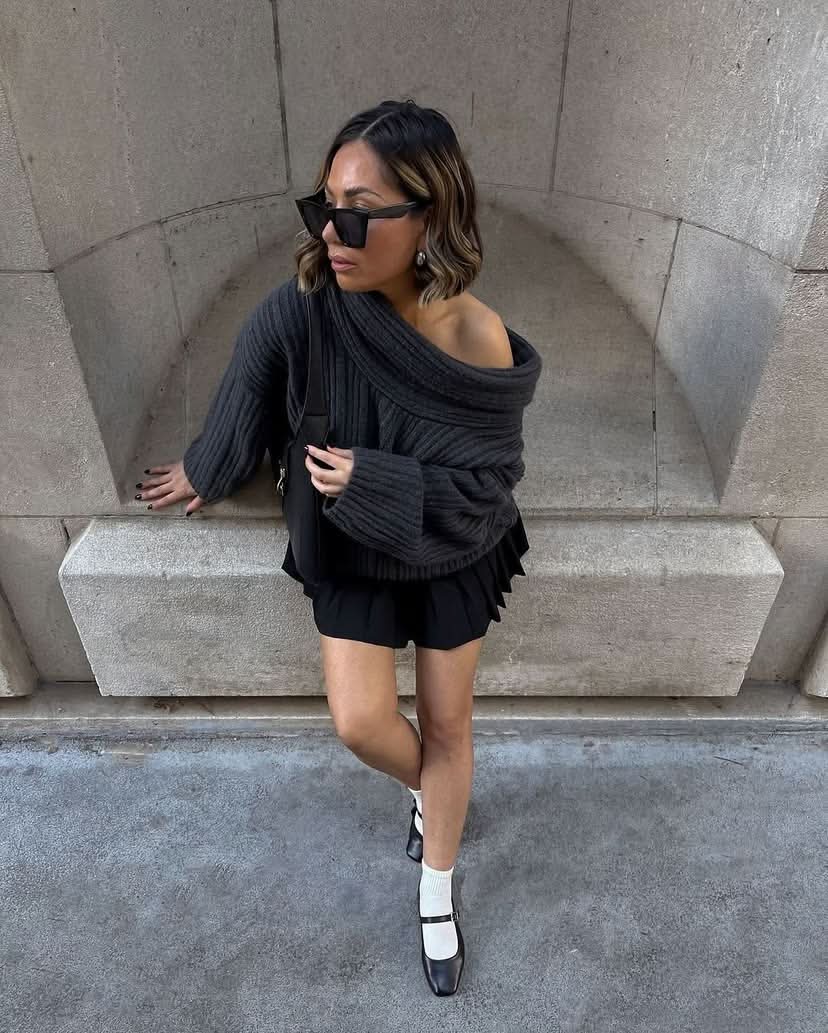 Black ribbed sweater with oversized cowl collar and relaxed fit silhouette