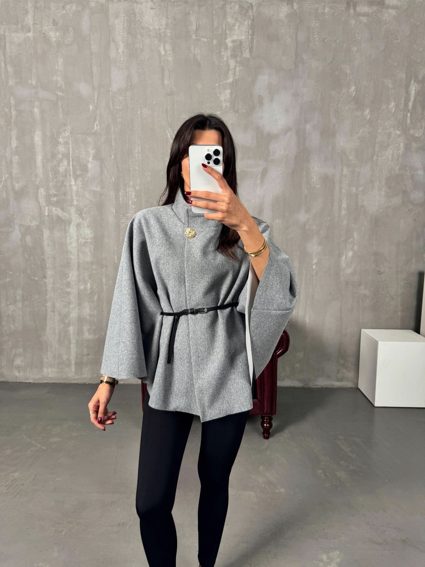 Gray poncho jacket front view with black belt and button closure detail