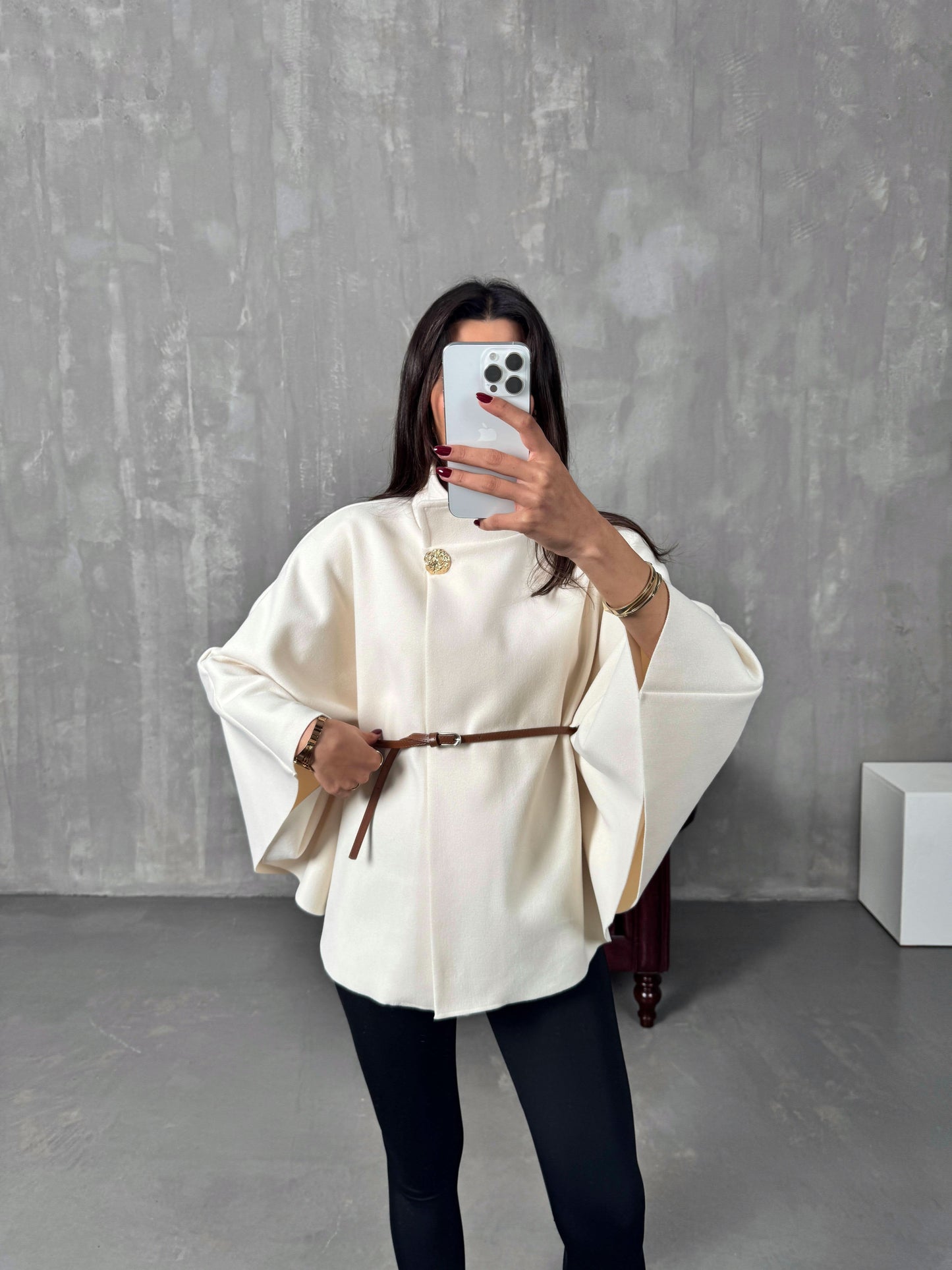 Cream belted poncho jacket with brown leather belt and gold brooch detail