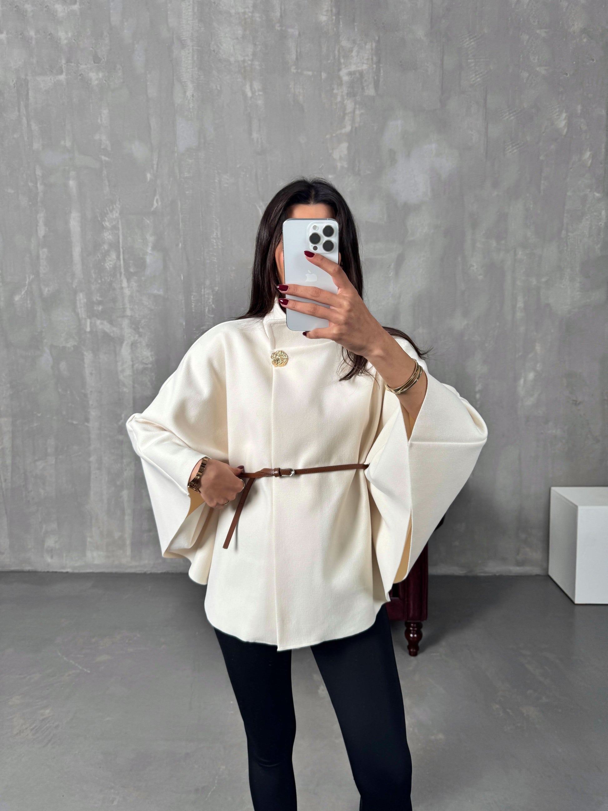 Cream belted poncho jacket with brown leather belt and gold brooch detail