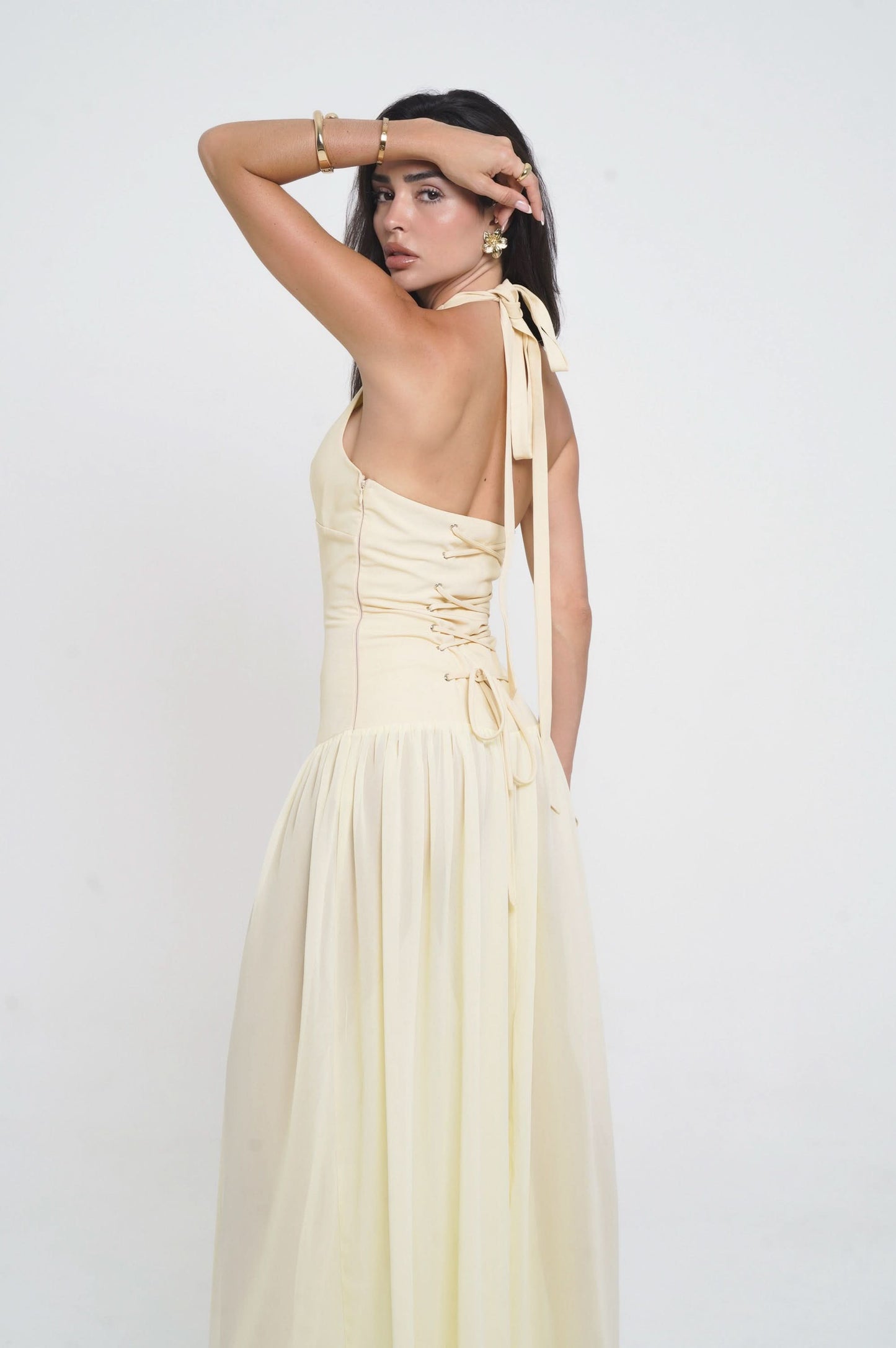 Back view of cream halter maxi dress with lace-up corset detail and open back