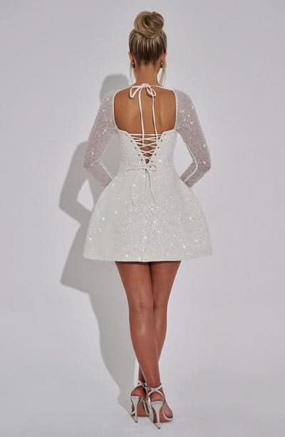 Back view of white sequin mini dress with lace-up corset back detail