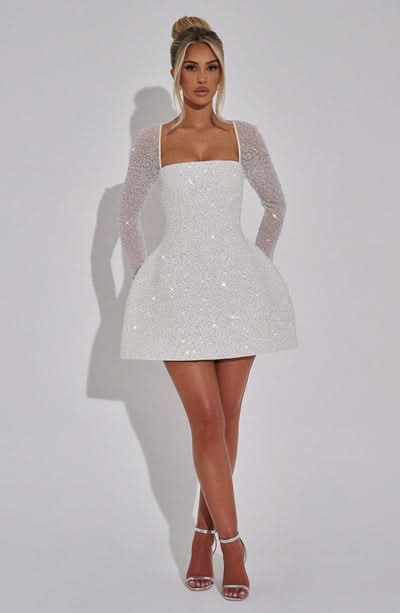 White sequin mini dress with square neckline and long sheer sleeves