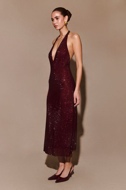 Side view of burgundy sequined maxi dress with plunging halter neckline