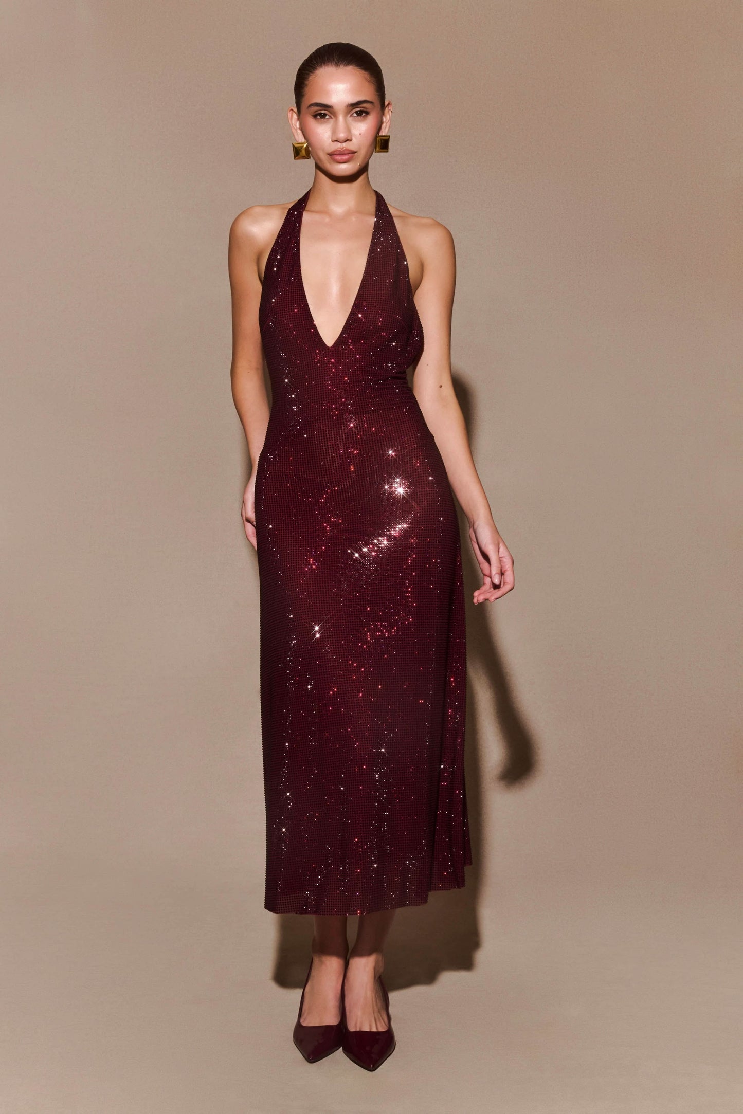 Burgundy sequin halter maxi dress with deep V-neckline and fitted silhouette