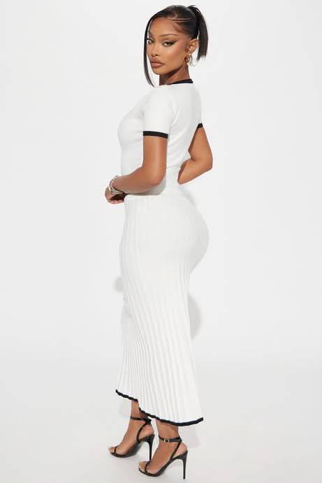 Back view of white ribbed skirt with black stripe hem and short-sleeve crop top