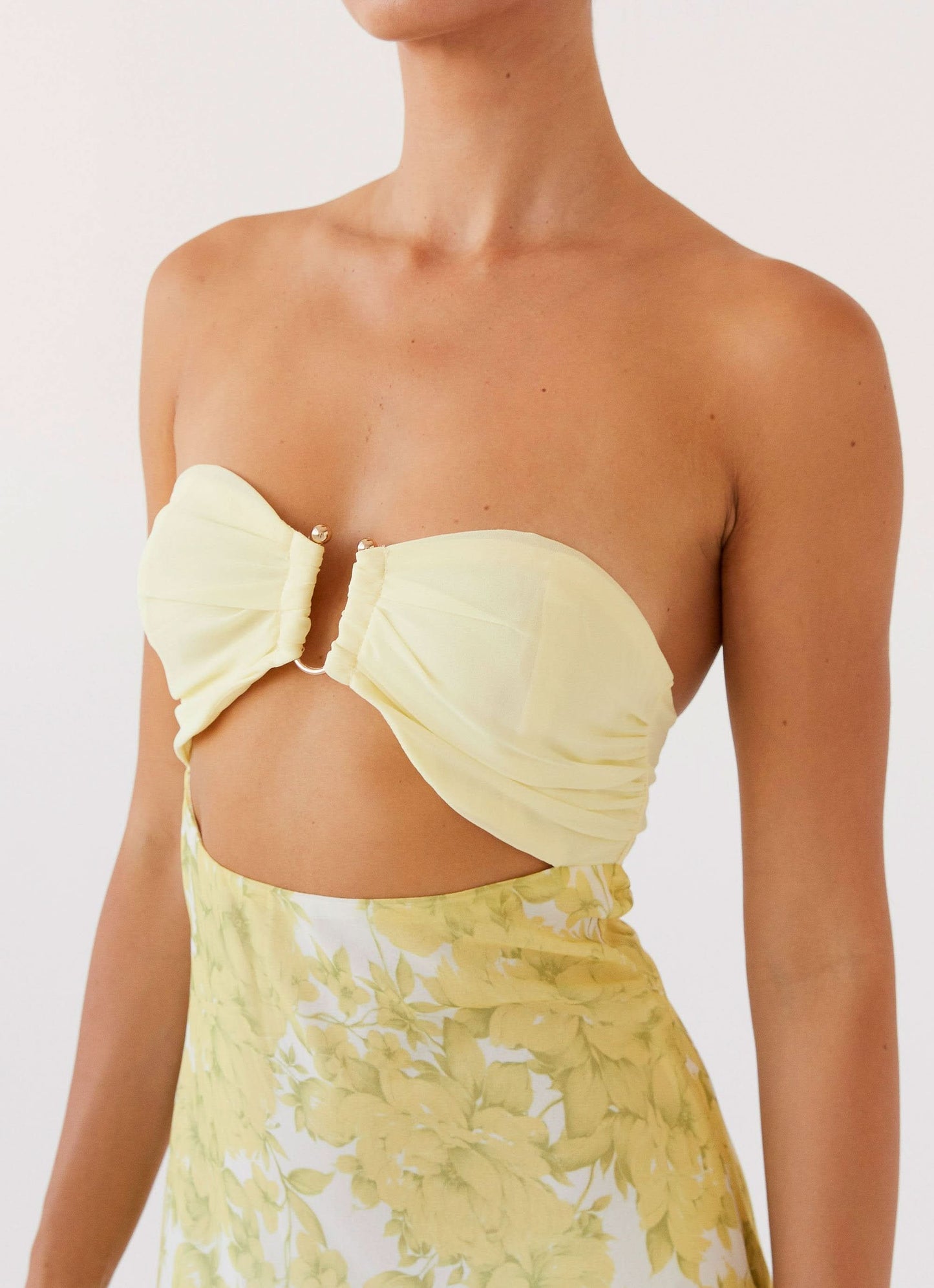 Close-up of cream bow cutout and ruched detail on maxi dress