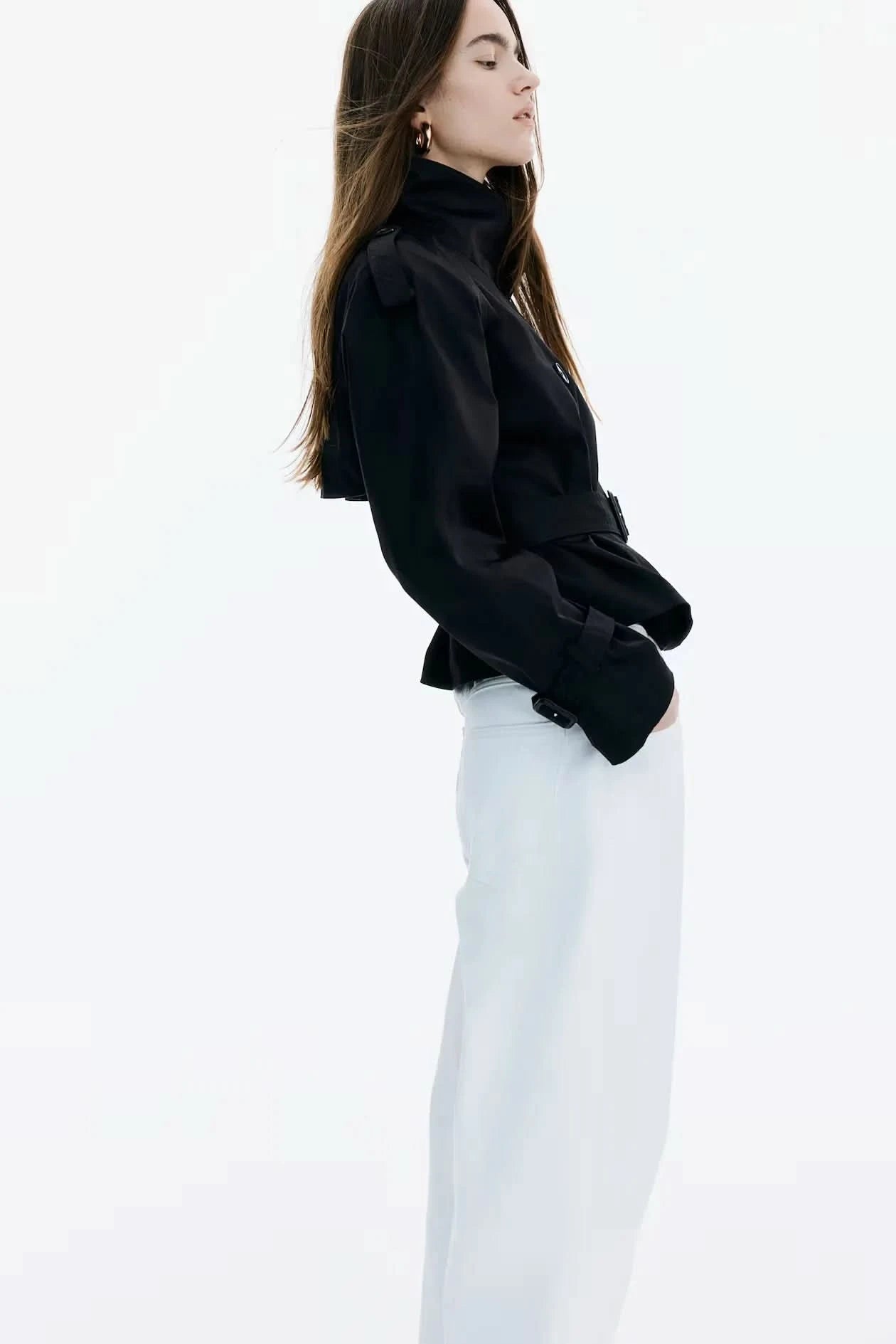 Black short trench coat side view showing cropped length and collar