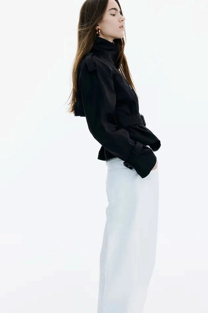 Black short trench coat side view showing cropped length and collar
