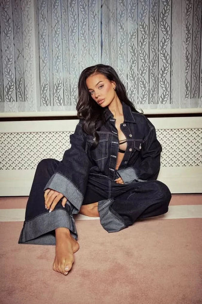 Dark denim two-piece set with cropped jacket and wide-leg jeans with rolled light blue hems