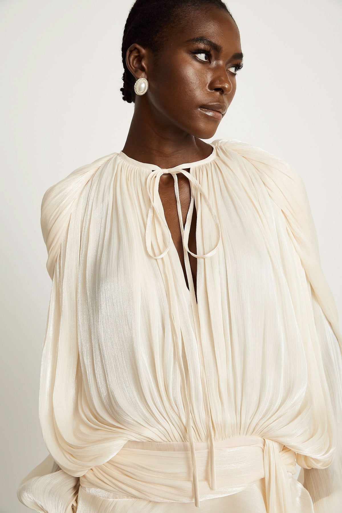 Close-up of cream ruffled mini dress neckline with tie detail