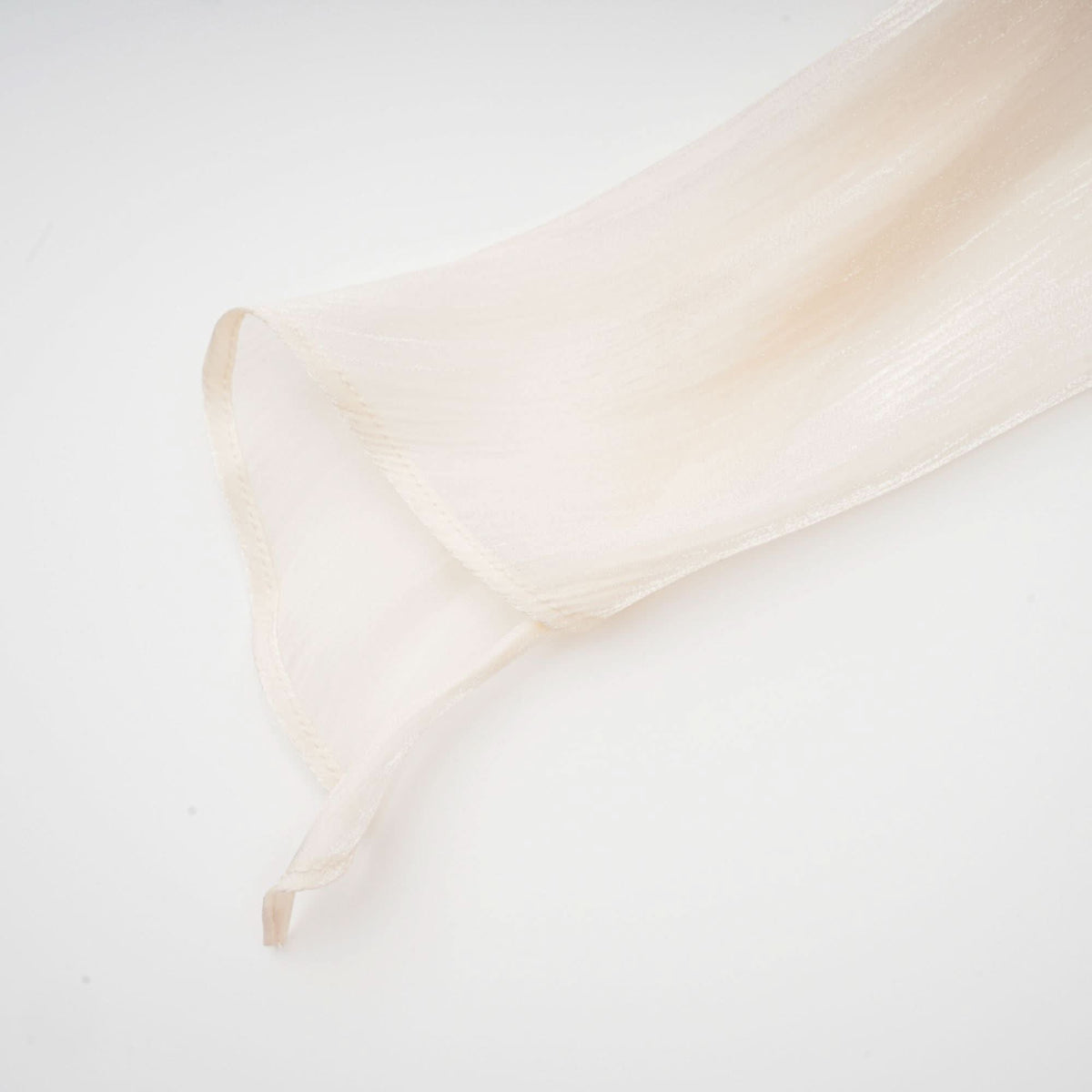 Cream pleated fabric sleeve showing delicate vertical pleating