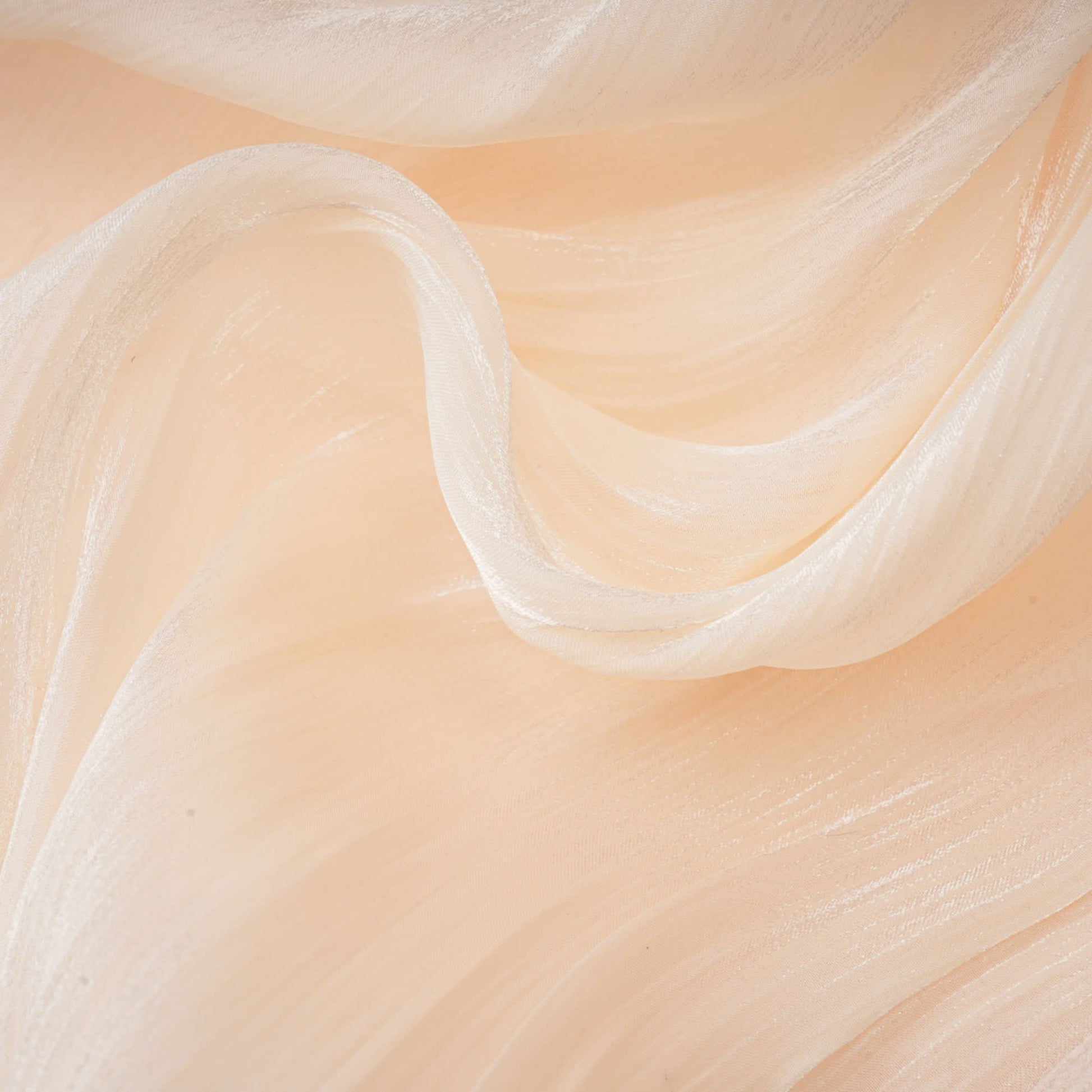 Close-up of cream mini dress ruffled edge and flowing fabric layers
