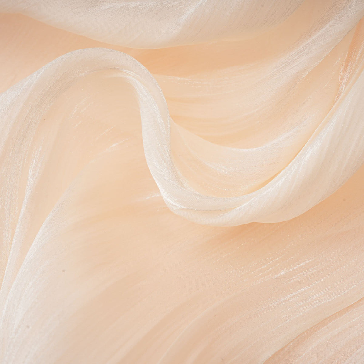 Close-up of cream mini dress ruffled edge and flowing fabric layers