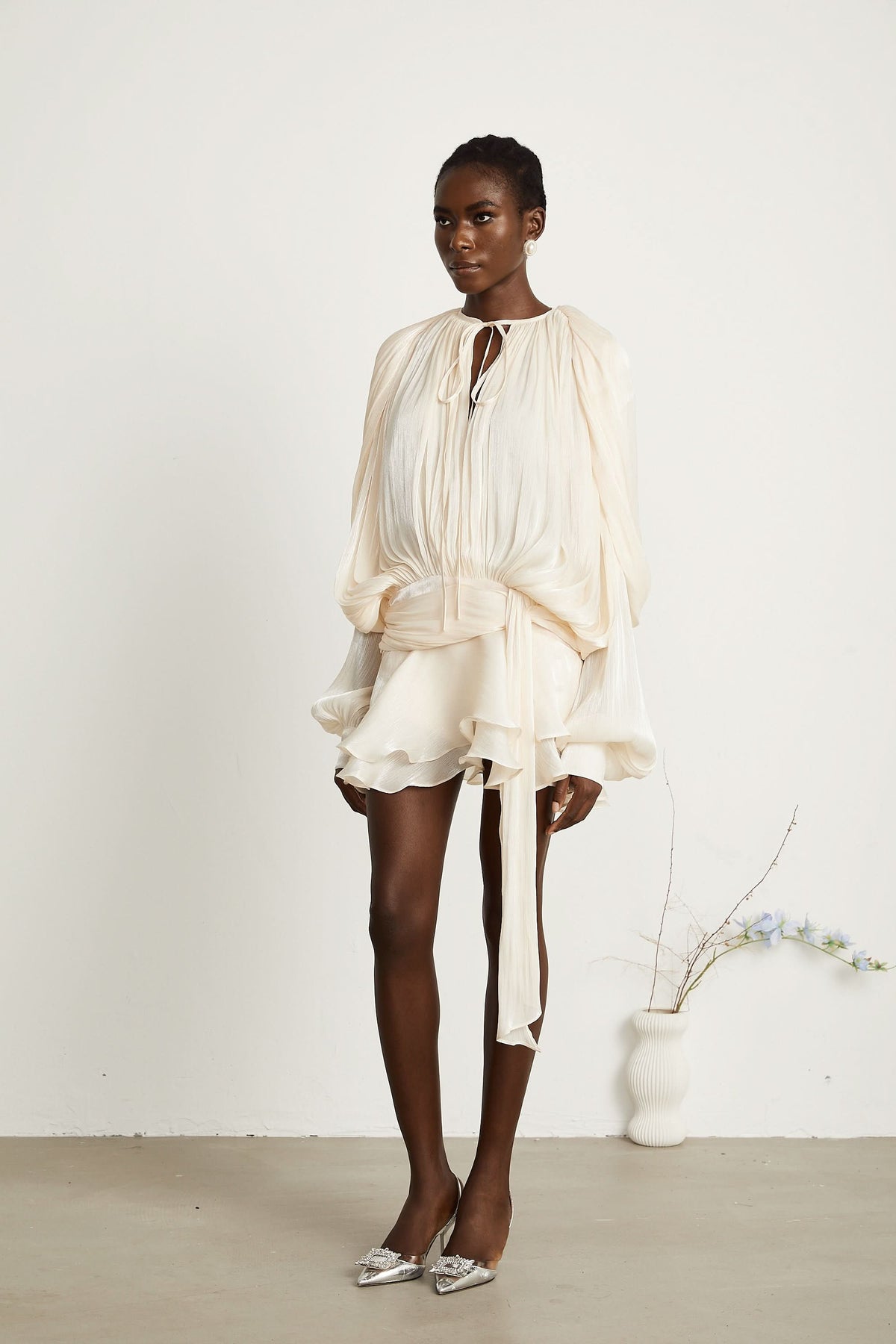 Cream ruffled mini dress with tie waist and layered ruffle hem detail
