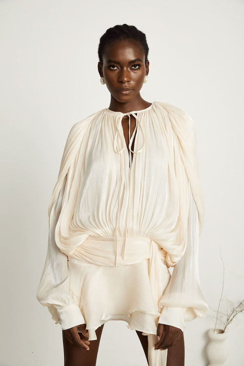 Cream pleated mini dress with ruffled hem and tie-neck keyhole cutout