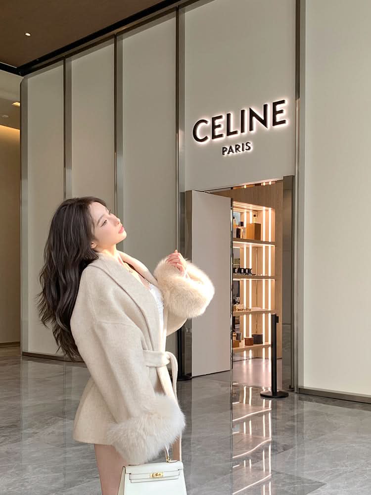 Cream luxury coat with fur-trimmed sleeves and tie waist, side view