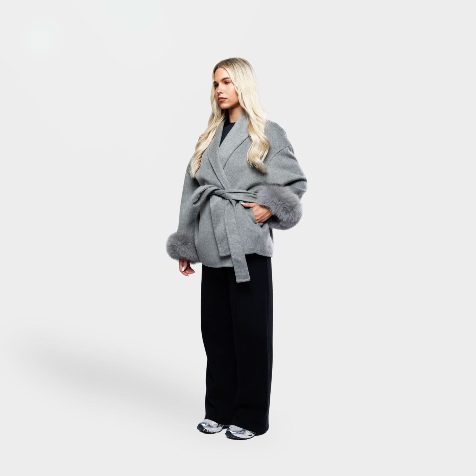 Gray wrap coat with fur-trimmed cuffs and tie belt, three-quarter view