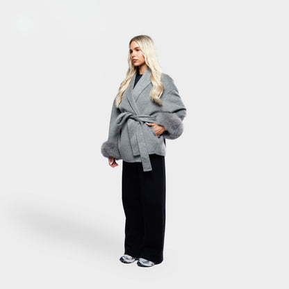 Gray wrap coat with fur-trimmed cuffs and tie belt, three-quarter view