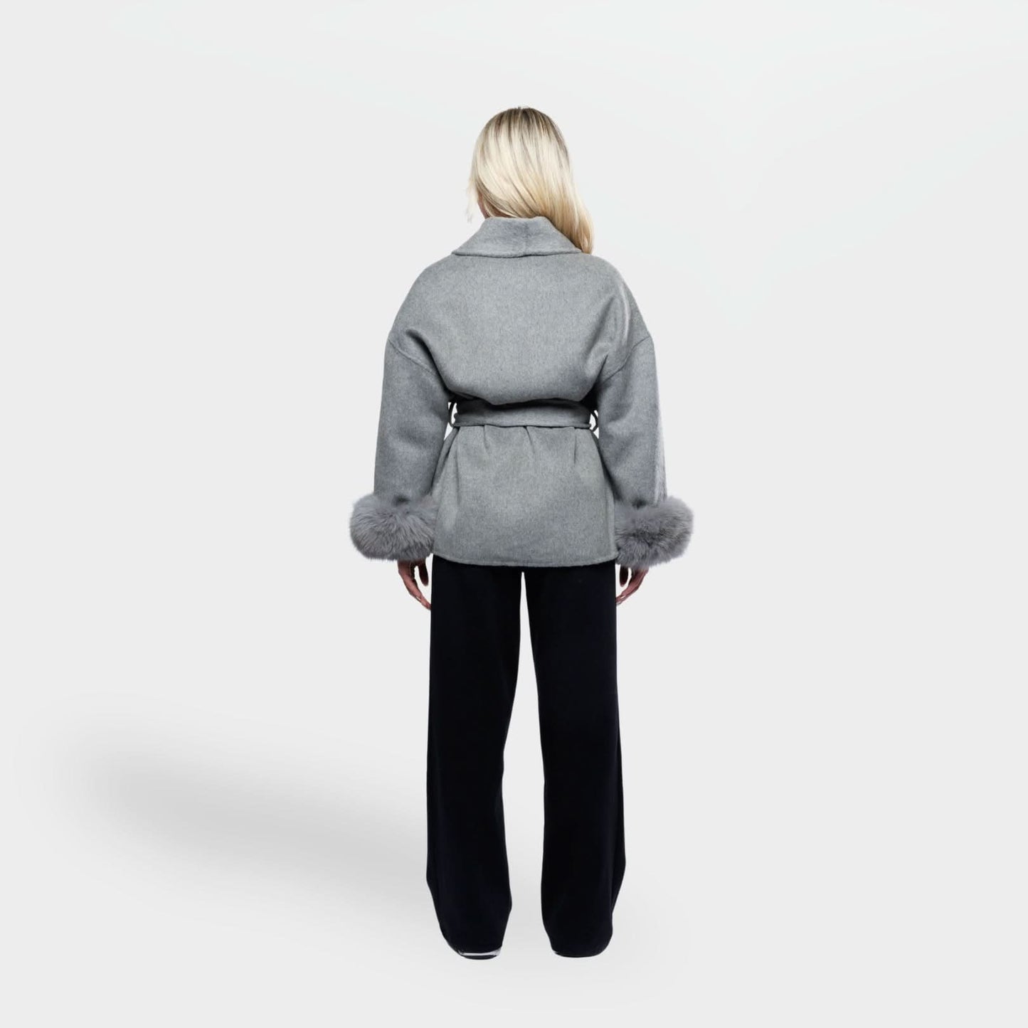 Gray wool coat with fur sleeve trim and cinched waist, back view