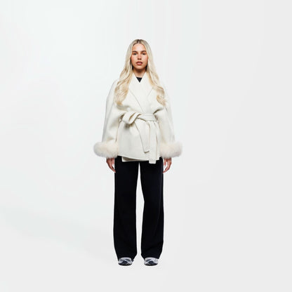 Cream wool coat with fur cuffs and tie waist closure, front view