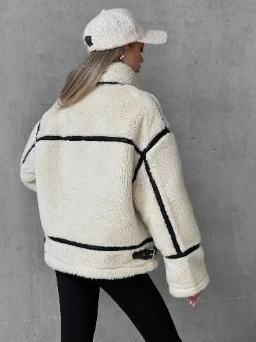 Back view of cream fleece teddy coat with black contrast piping and seams