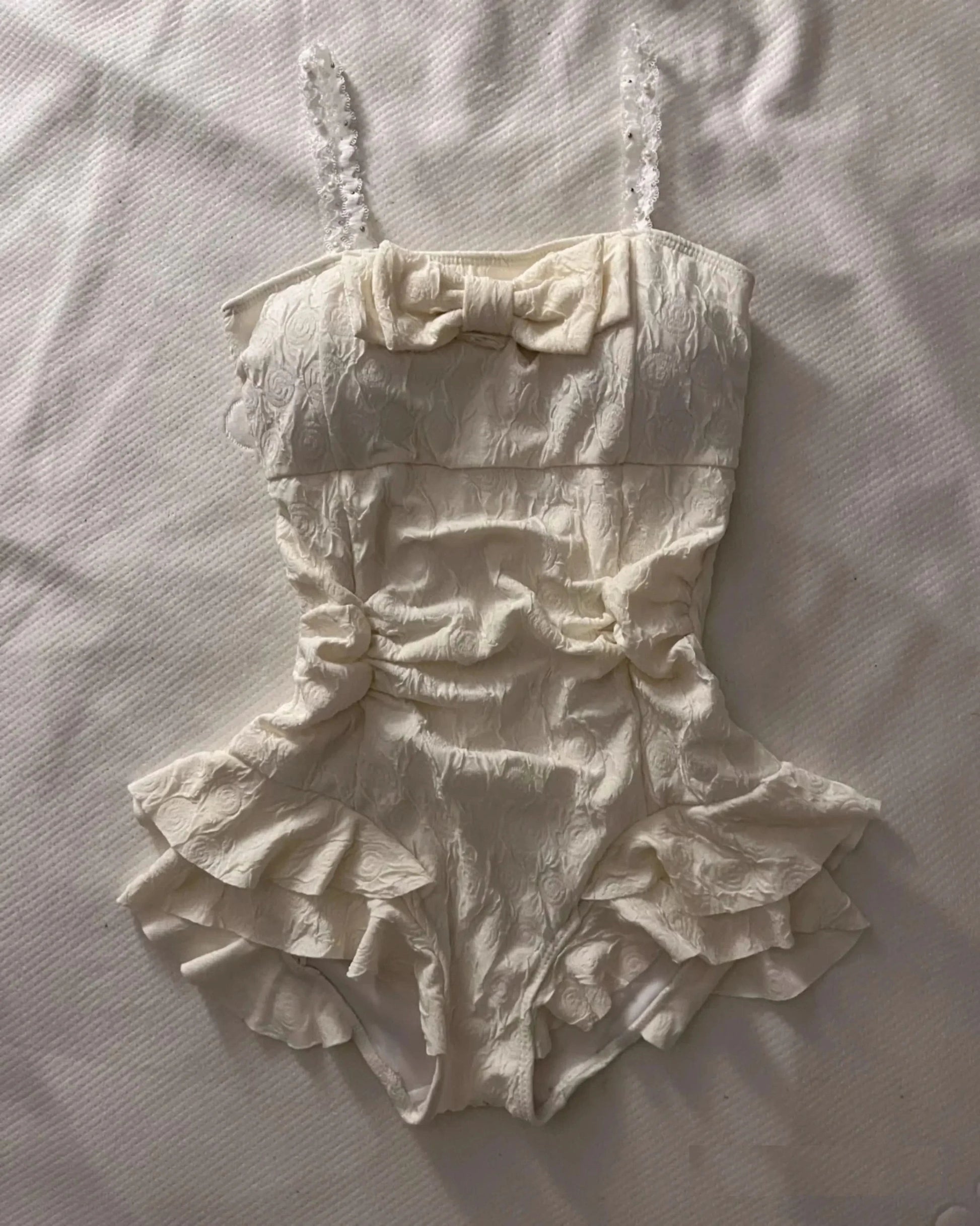 Cream textured floral one-piece swimsuit with square neckline and ruffled skirt for women