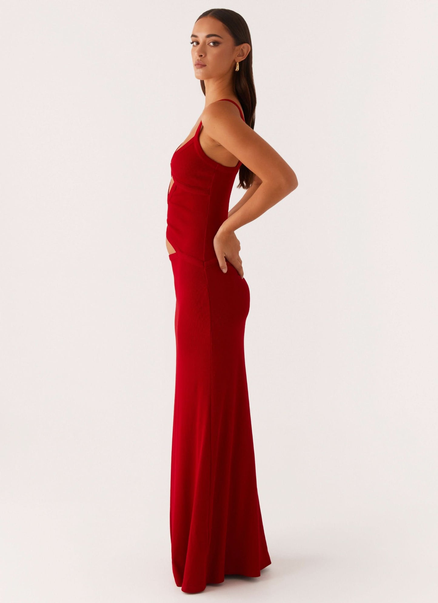 Side view of red maxi dress with side cutout and flowing skirt