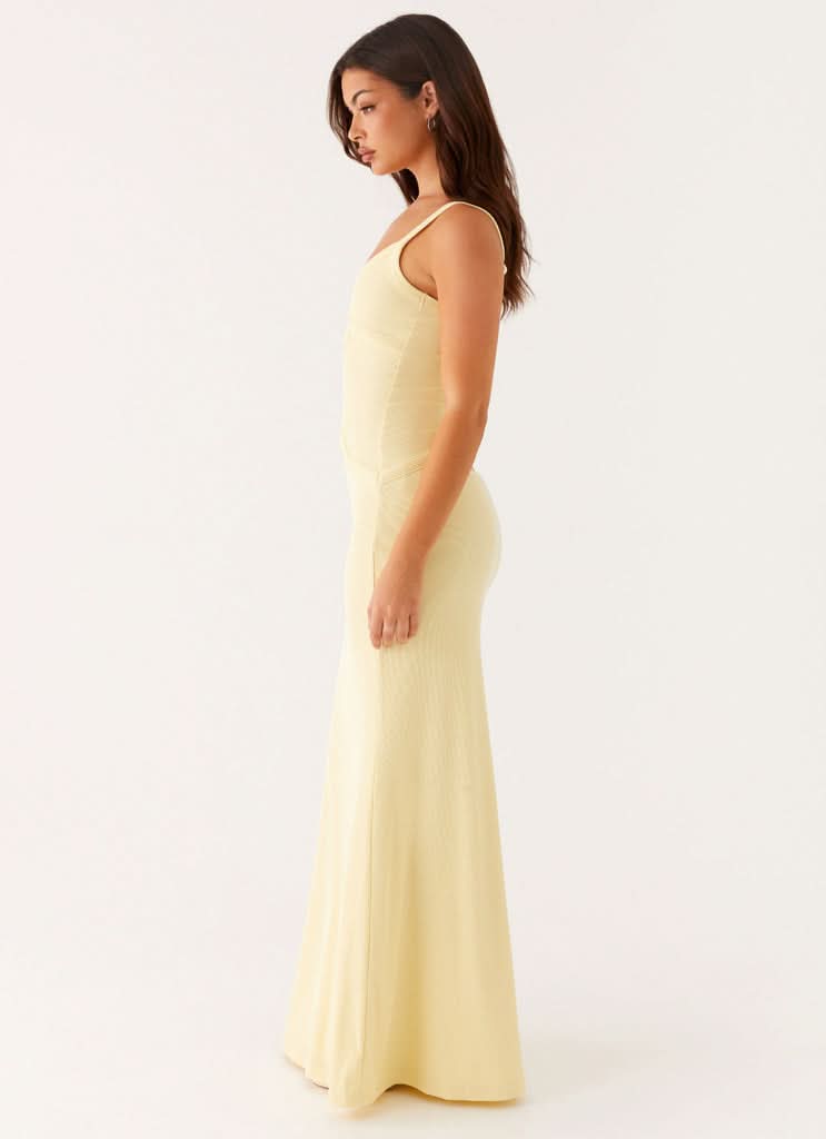 Side profile of pale yellow maxi dress with cutout details and thin straps