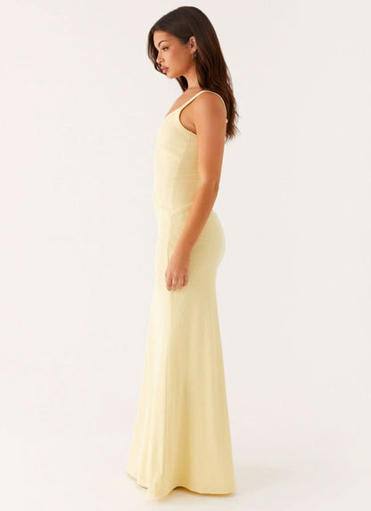 Side profile of pale yellow maxi dress with cutout details and thin straps